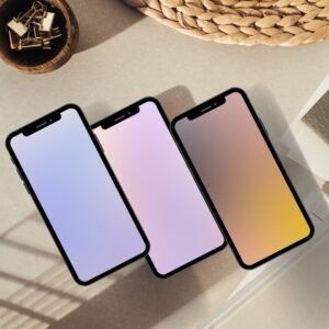 Three iPhone mockups displaying nice iPhone wallpapers with soft gradient mobile wallpaper designs in periwinkle blue, lilac pink and golden sunset tones, styled on a neutral flat lay background.